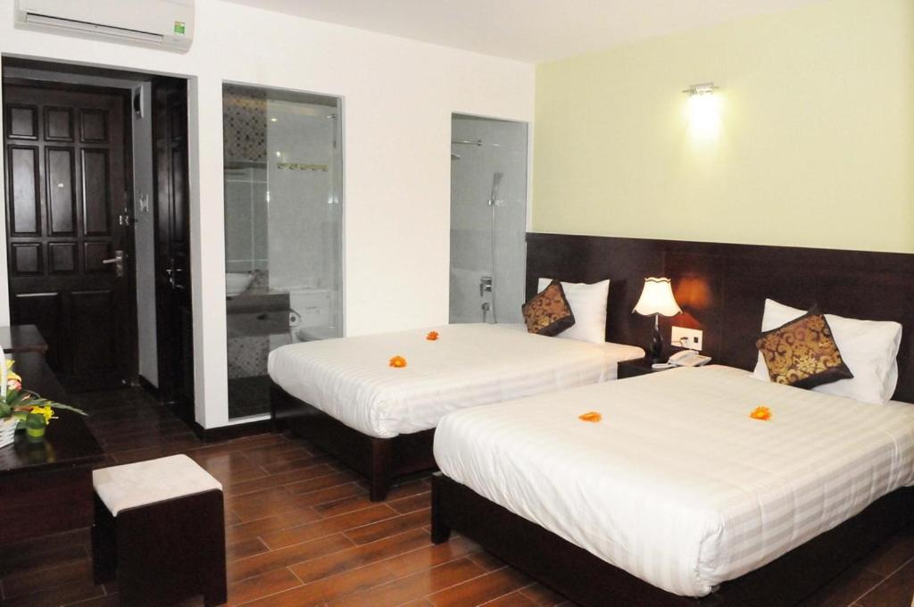 Postel nebo postele na pokoji v ubytování Dragon Sea Hotel