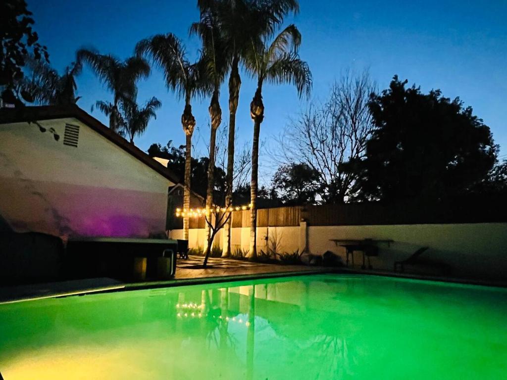 a swimming pool in front of a house with palm trees at Mediterranean Villa Pool & Jacuzzi & BBQ Malibu & Hollywood Bliss in Los Angeles