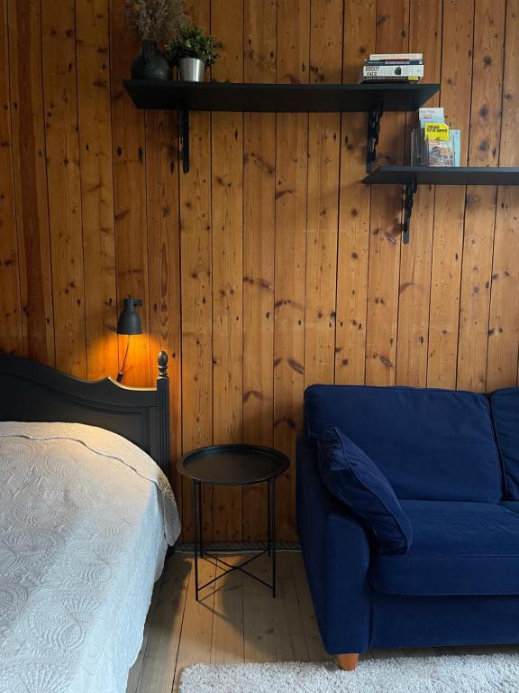 a bedroom with a blue couch and a table at Hipster’s Kalamaja Studio Apartment in Tallinn