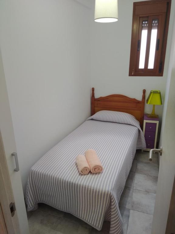 - une chambre avec un lit et 2 serviettes dans l'établissement Apartamentos Andalucía, à Algésiras