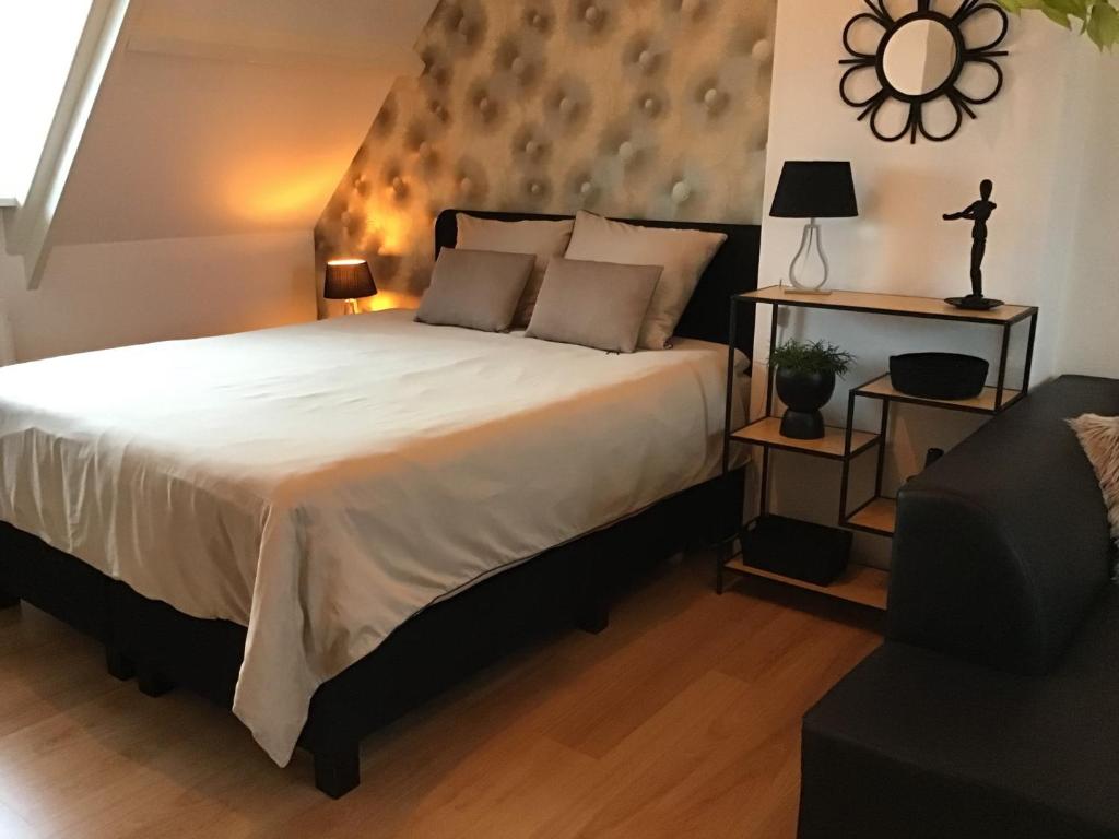 a bedroom with a large white bed and a chair at Sunny dunes in Zandvoort