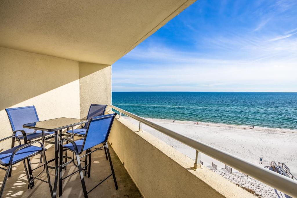 a balcony with a table and chairs and the beach at Perdido Sun Resort 704 By Pkrm in Pensacola
