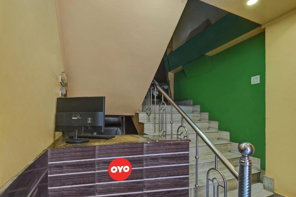 a room with a staircase with a tv and green wall at OYO Flagship Hotel Dream Plaza in Aurangābād