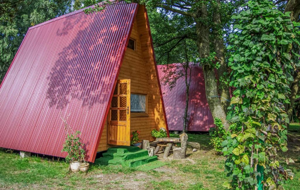 a small wooden cabin with a red roof at 1 Bedroom Lovely Home In Mielno in Mielno