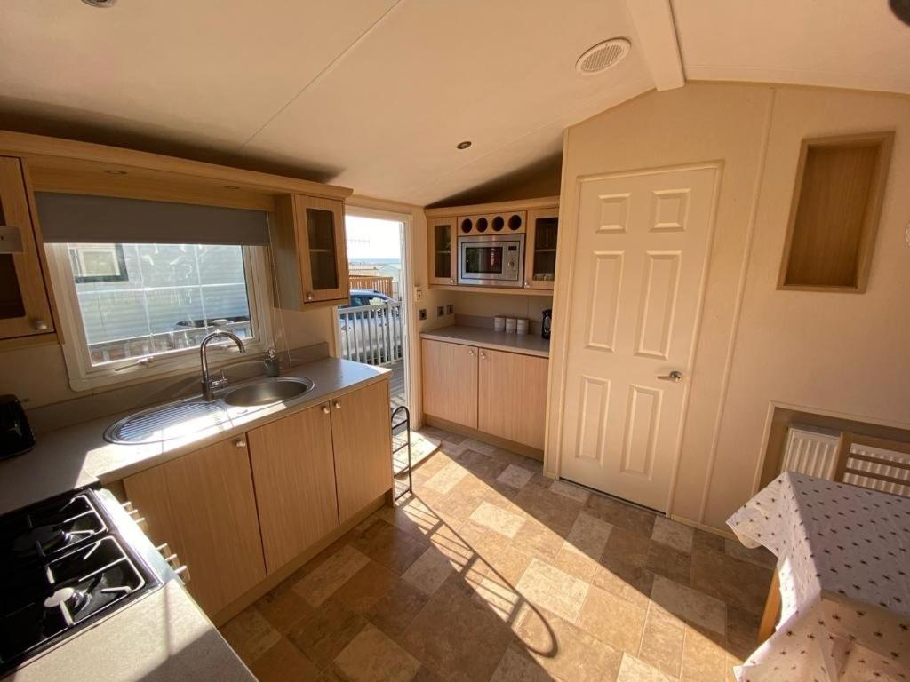 a kitchen with a sink and a stove at Ocean View Sunbeach in Llwyngwril