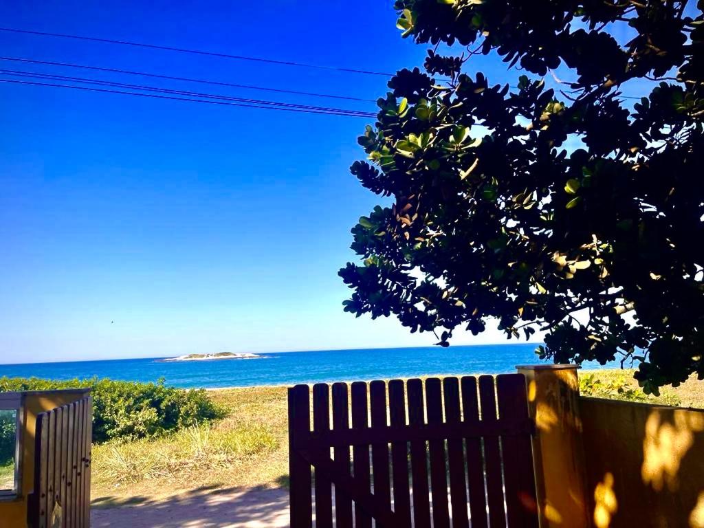 uma vista para o oceano por trás de uma cerca de madeira em Casa á Beira-Mar Praião, Prainha, Barra de São João em Barra de São João