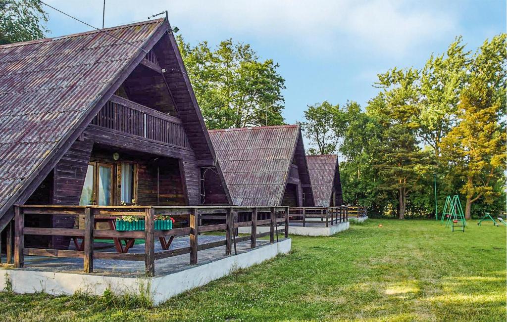 two large wooden buildings with a playground in a field at Amazing Home In Mielno With Kitchen in Mielno