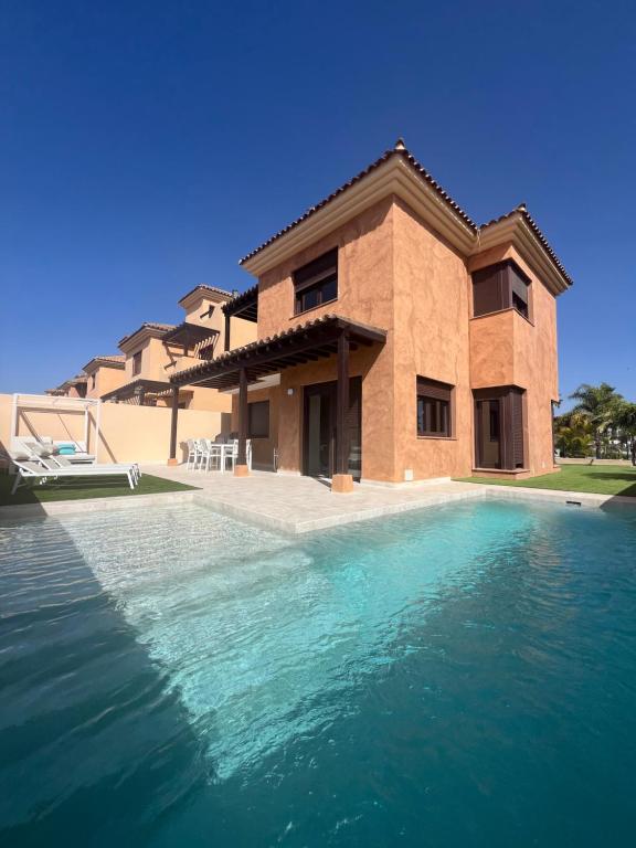 una casa con piscina frente a ella en Villa Saona Golf, en San Miguel de Abona