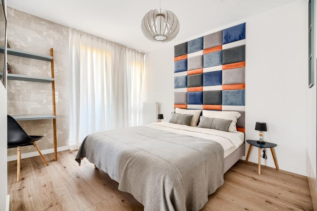 een slaapkamer met een groot bed met een kleurrijk hoofdeinde bij Apartament Pułaskiego z garażem in Toruń