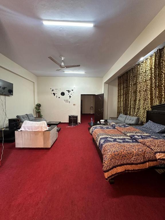 a hotel room with two beds and a red carpet at Islamabad lodges apartment suite in Islamabad