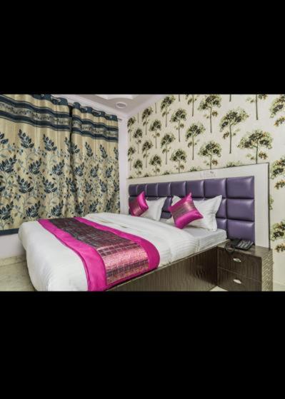 a bedroom with a large bed with a purple headboard at HOTEL AKASH CONTINENTAL in New Delhi