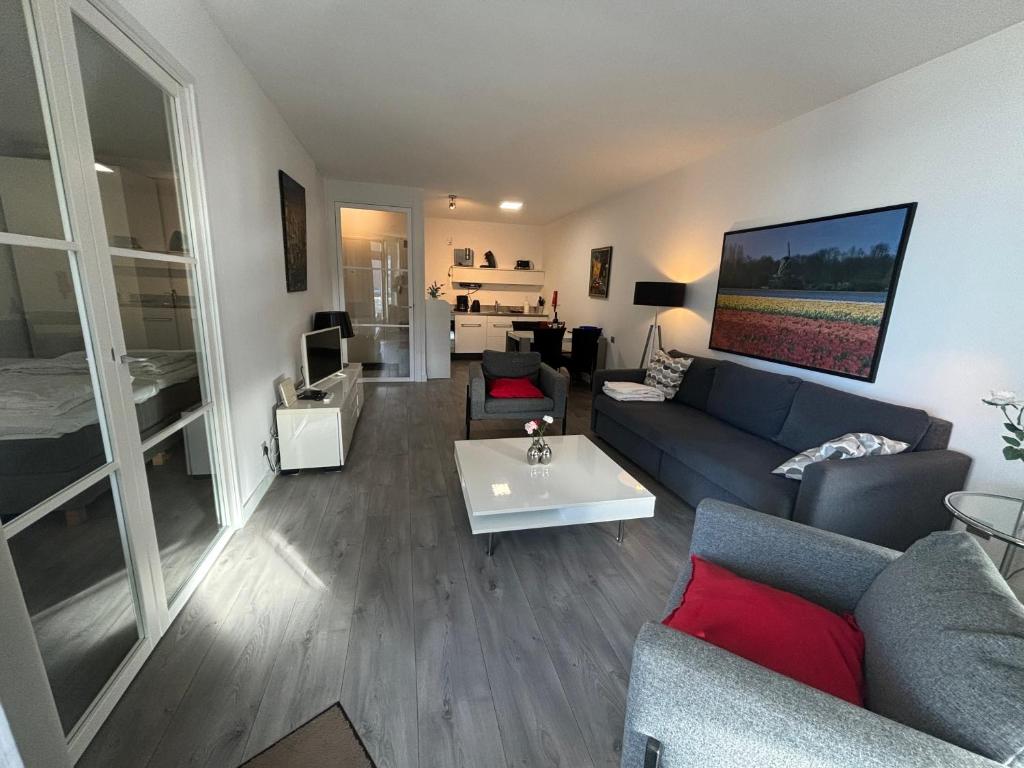 een woonkamer met een bank en een tv bij Sterflat 83 in Egmond aan Zee