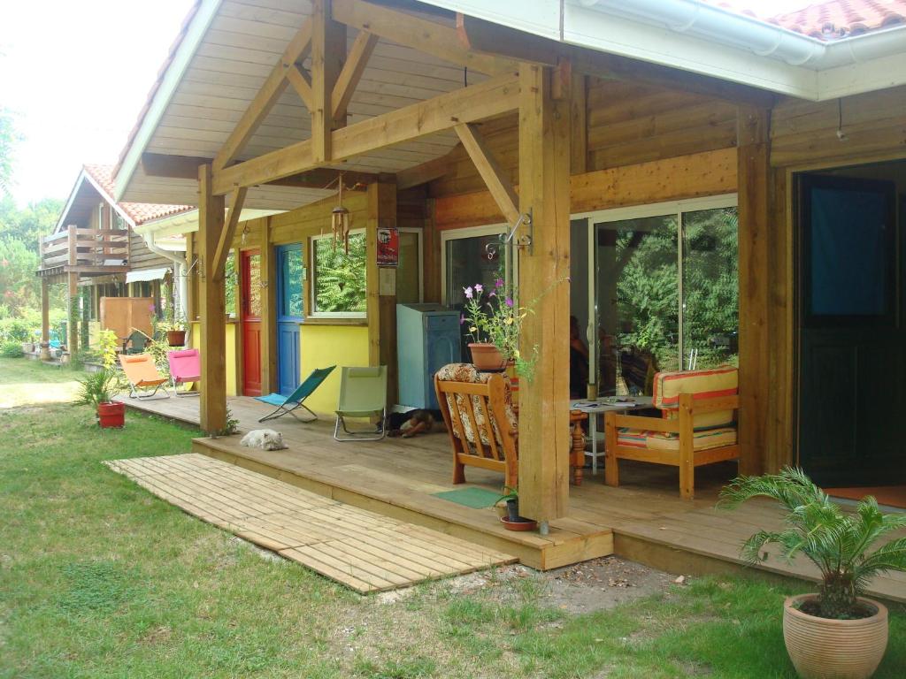 una piccola casa con terrazza in legno e tavolo di Les Hébergements Nature et Bien-être a Soustons