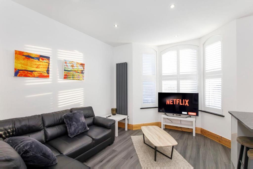 a living room with a couch and a tv at The Residence At The Lawrence Apartments in York