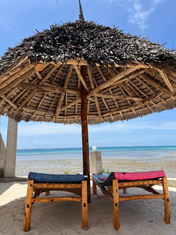 dos sillas bajo una sombrilla en la playa en Bwereu Sunset Villas 
