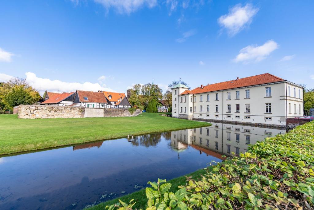 ein Gebäude neben einem Wasserkörper in der Unterkunft Schlosshotel Westerholt in Herten