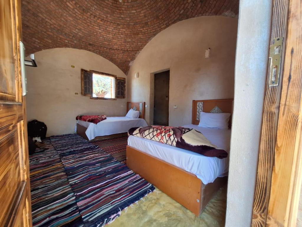 Mezorin Camp في سيوة: غرفة نوم بسريرين في غرفة