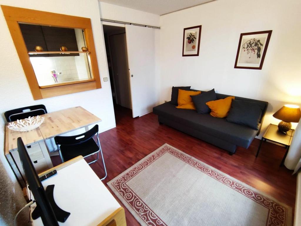 un salon avec un canapé et une table dans l'établissement Charmant studio au calme avec balcon et internet - FR-1-292-108, à Isola 2000