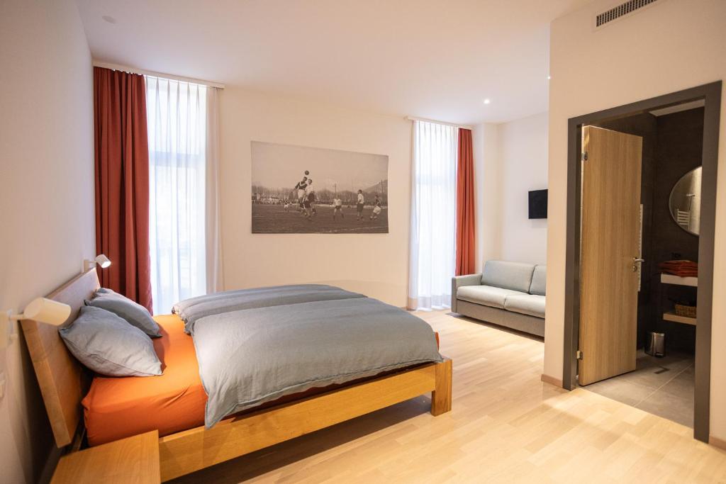 a bedroom with a bed and a living room at Locanda della Masseria in Porza