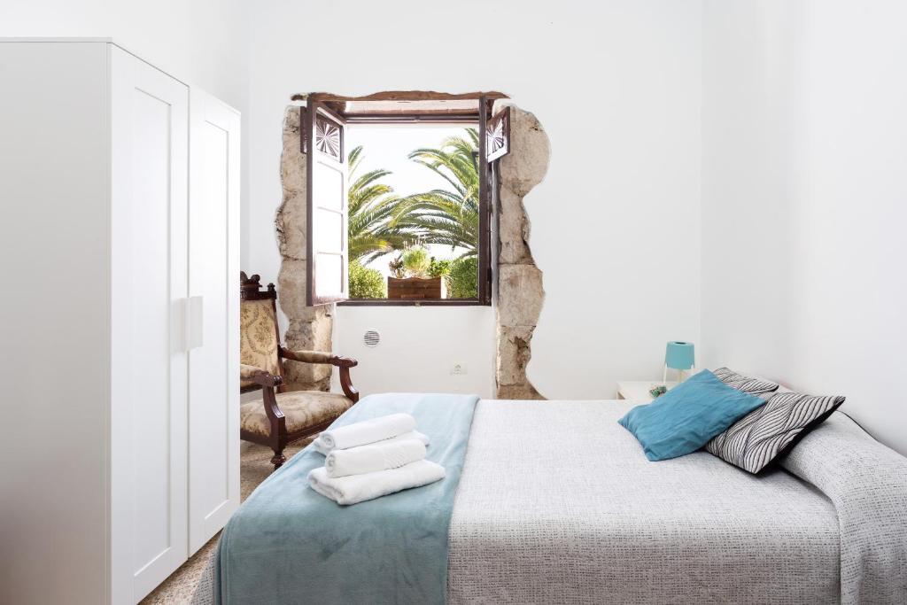1 dormitorio con 1 cama con toallas en El Hostal del Cubo en San Juan de la Rambla