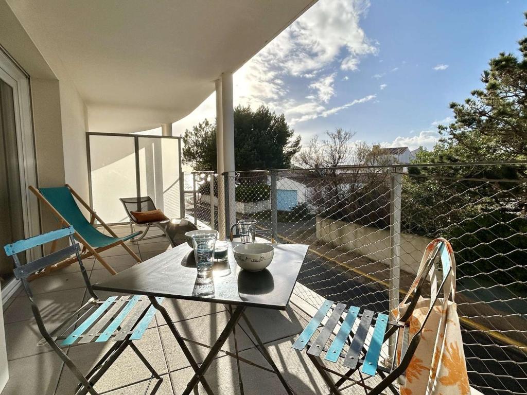 un patio con tavolo e sedie sul balcone. di Appartement La Guérinière, 2 pièces, 2 personnes - FR-1-224B-171 a La Guérinière