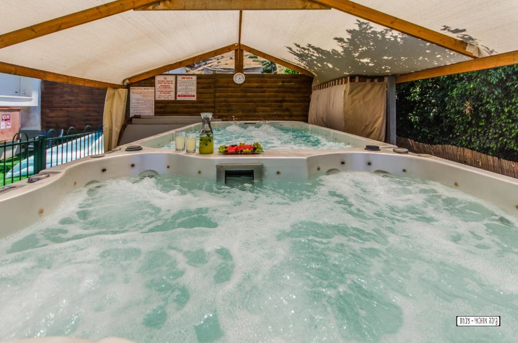 eine große Whirlpool-Badewanne in einem Zelt mit Wasser in der Unterkunft Avigail Guest House in Jabneel