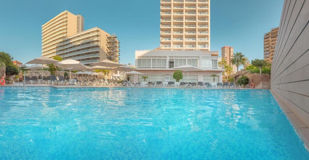 a large swimming pool with buildings in the background at Hotel RH Victoria & Spa in Benidorm