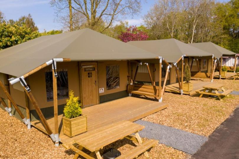 ein großes Zelt mit einer Holzterrasse auf einem Feld in der Unterkunft Cottage de Luxe in Harderwijk