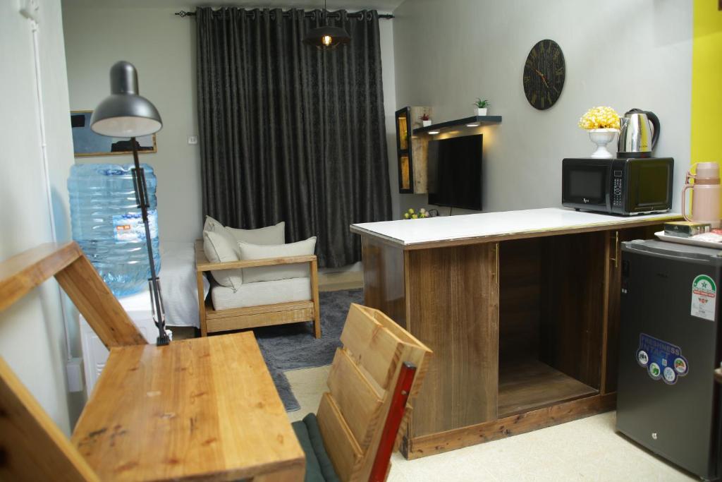 a living room with a kitchen with a table and a microwave at Enn lovely apartment 11 in Bungoma