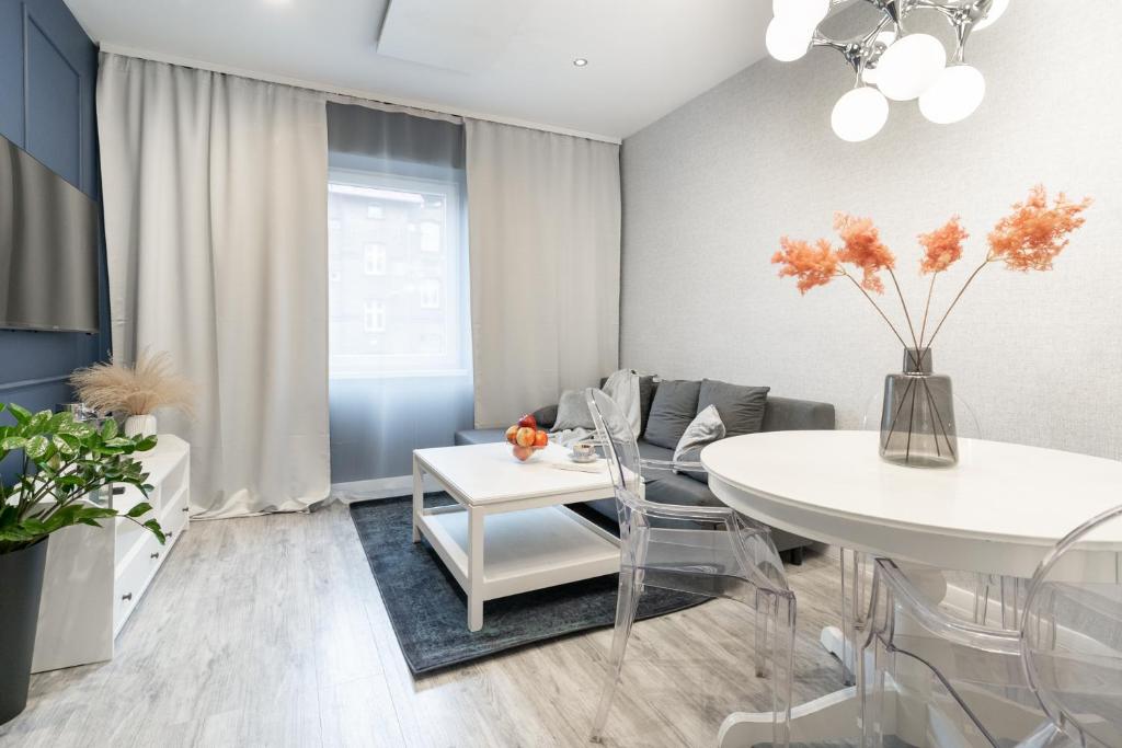 a dining room with a white table and chairs at Apartament BIANCO w sercu Śląska in Ruda Śląska