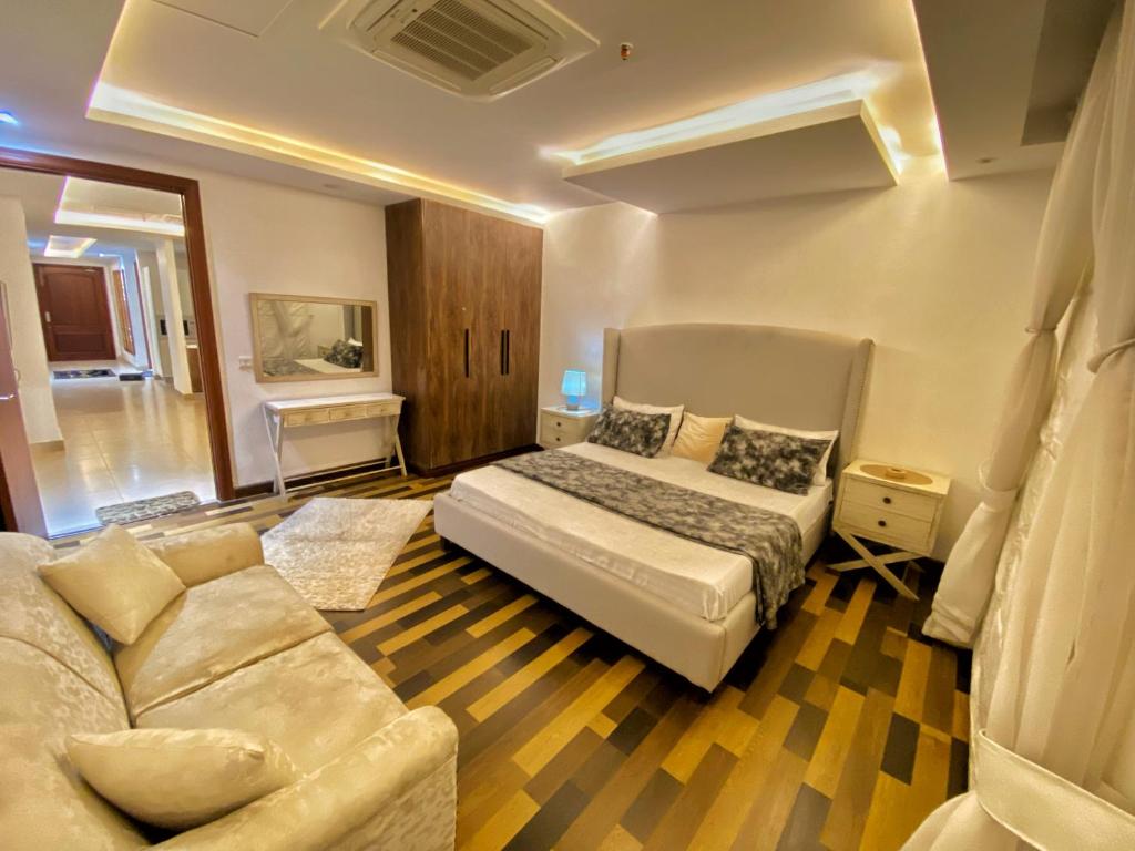 ein Schlafzimmer mit einem Bett und einem Sofa in der Unterkunft Gold crest Mall, The Aesthetic one bed suite in Lahore