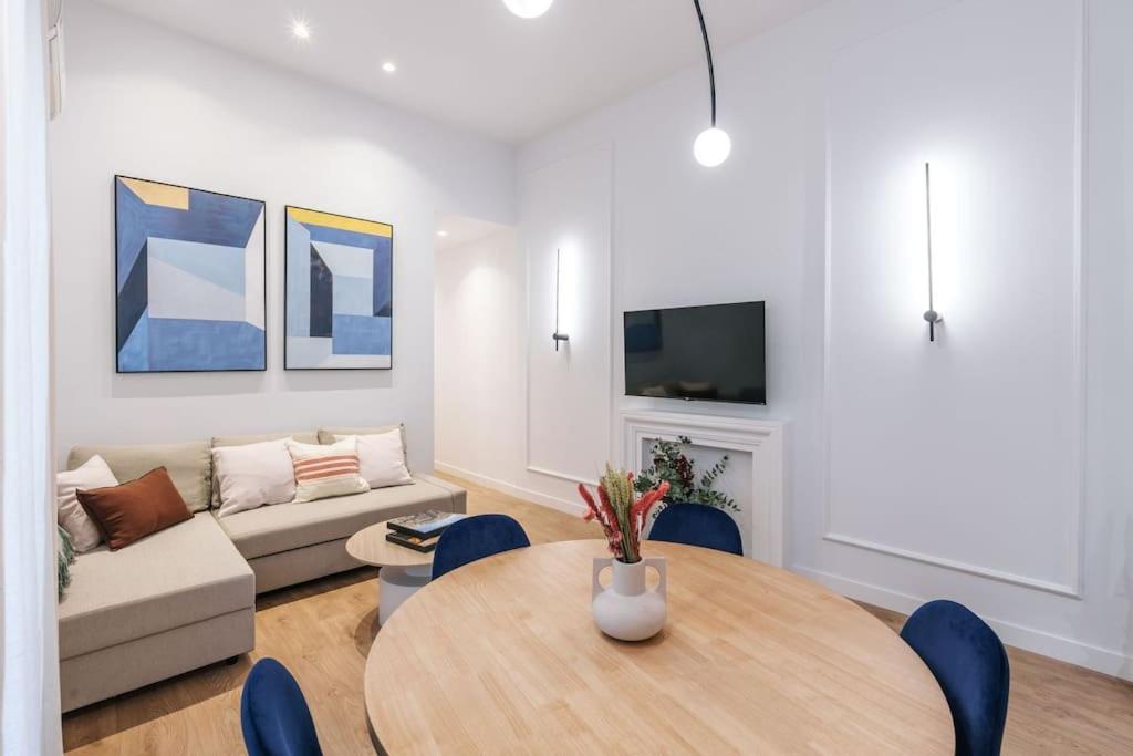 een woonkamer met een tafel en een bank bij New Luxury flat next to Gran Vía in Madrid