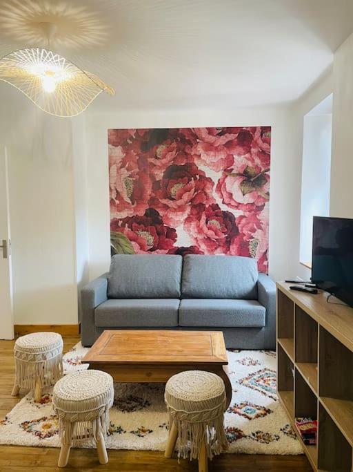 - un salon avec un canapé bleu et deux tabourets dans l'établissement Le logis de la lanterne*Centre Historique de Sarlat, à Sarlat-la-Canéda