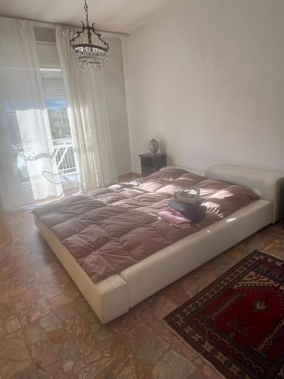 un grande letto in una camera da letto con lampadario a braccio di ALE HOME a Pescara