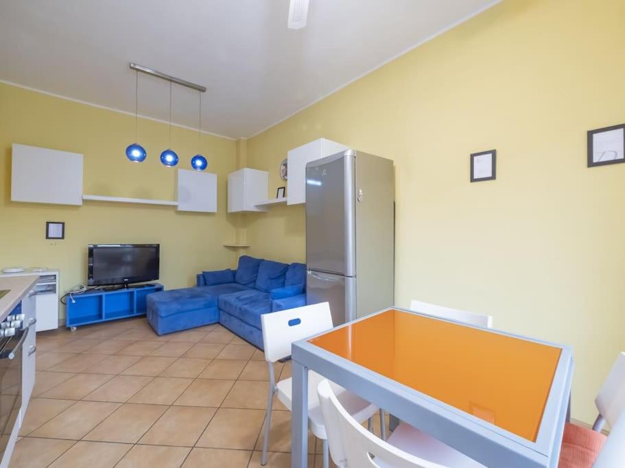 een keuken en een woonkamer met een blauwe bank bij Youhosty - Paul Valery 3 in Milaan