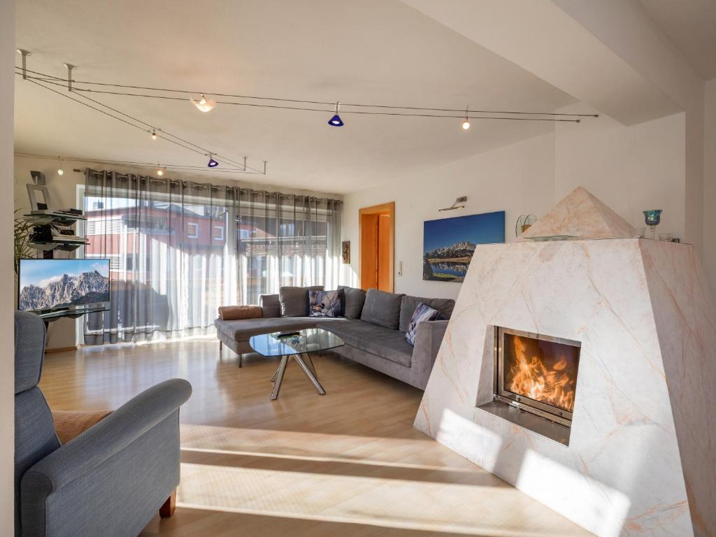 ein Wohnzimmer mit einem Sofa und einem Kamin in der Unterkunft Exklusiv Apartment Hofer in Sankt Johann in Tirol