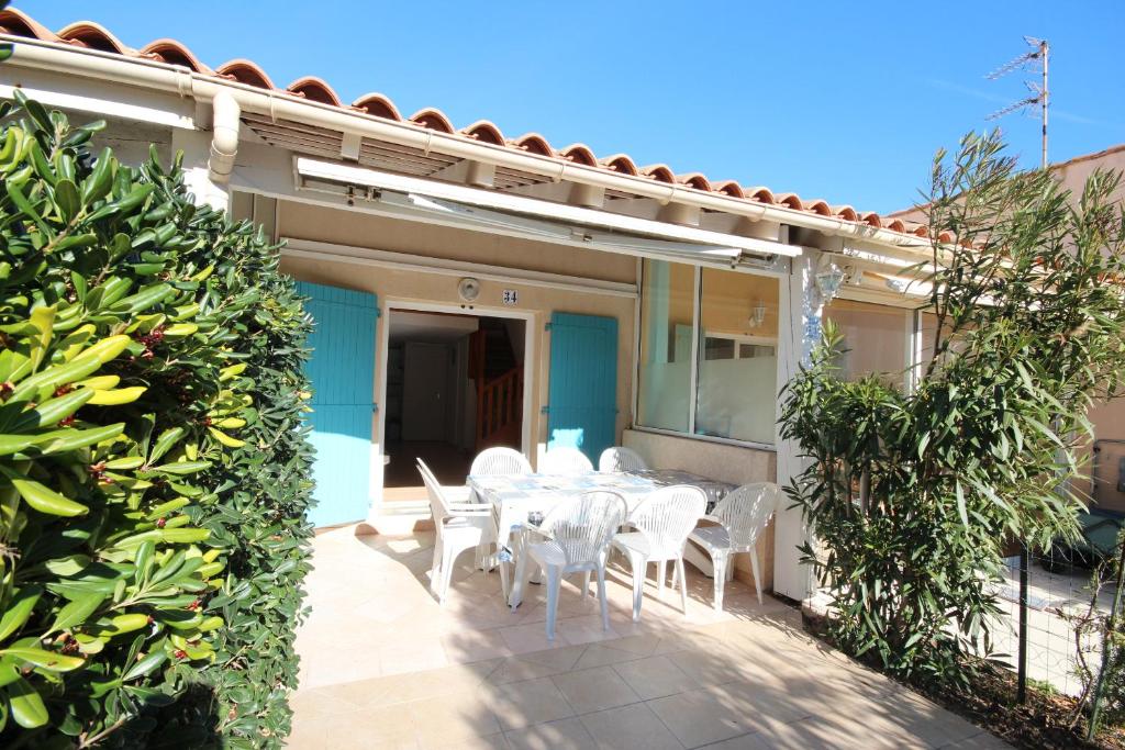 une table et des chaises sur le patio d'une maison dans l'établissement Villa 4 couchages terrasse sud parking piscine commune dans résidence sécurisée à 200m de la mer LRMA34, à Portiragnes