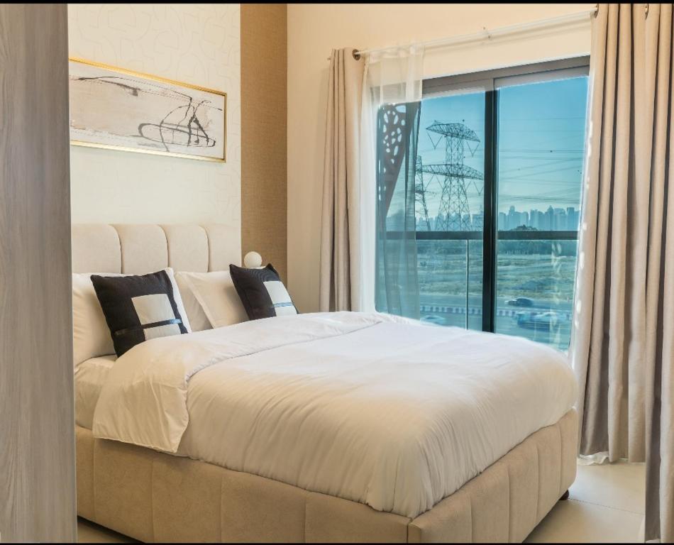 een slaapkamer met een groot bed en een raam bij Autumn Falls, 2 Bedroom full service equipped appartement in Dubai