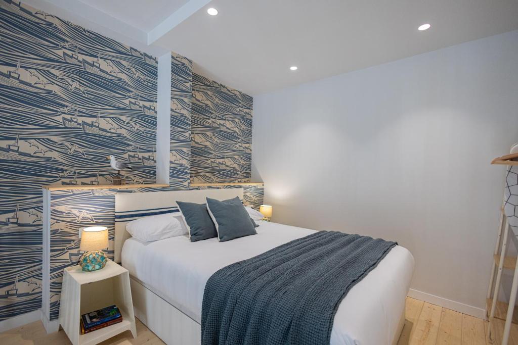 Un dormitorio con una cama blanca con una pared de acento azul en FLORIT FLATS - The Mediterraneo Apartments, en Valencia