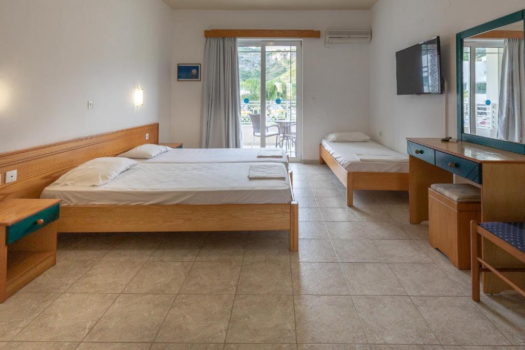 羅德島卡利地亞的住宿－Faliraki Dream Apartment 1，一间卧室配有两张床、一台电视和镜子
