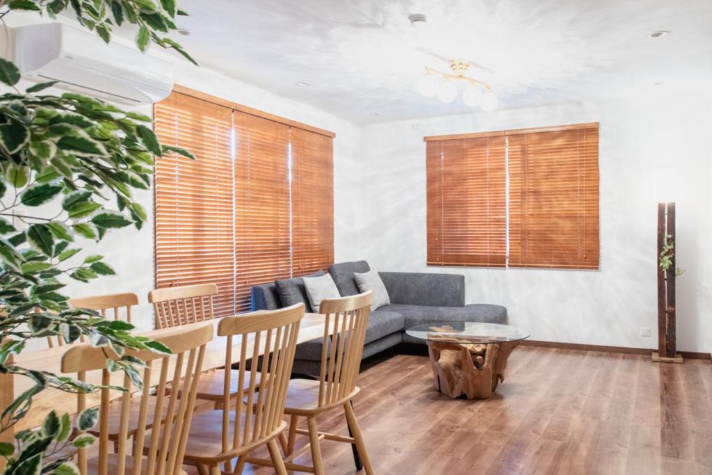 a living room with a couch and a table and chairs at Residencial Voyan 南砂町 in Tokyo