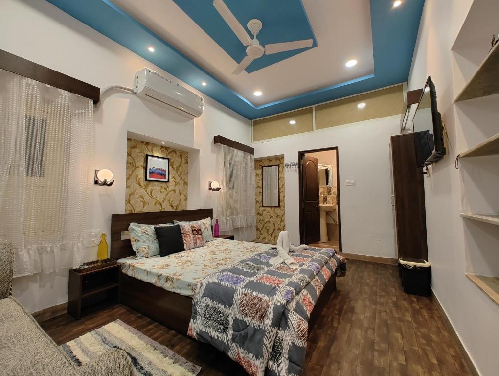een slaapkamer met een bed en een televisie en een plafond bij Leisure Homestay in Udaipur