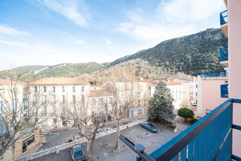 une vue d'une ville depuis un balcon dans l'établissement Tadasana - Studio vue montagne, à Amélie-les-Bains-Palalda