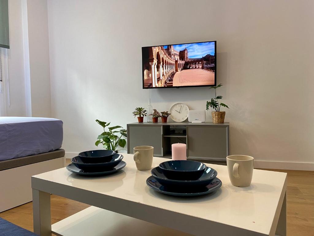a living room with a table with plates on it at Nuevo estudio junto al Guadalquivir in Seville