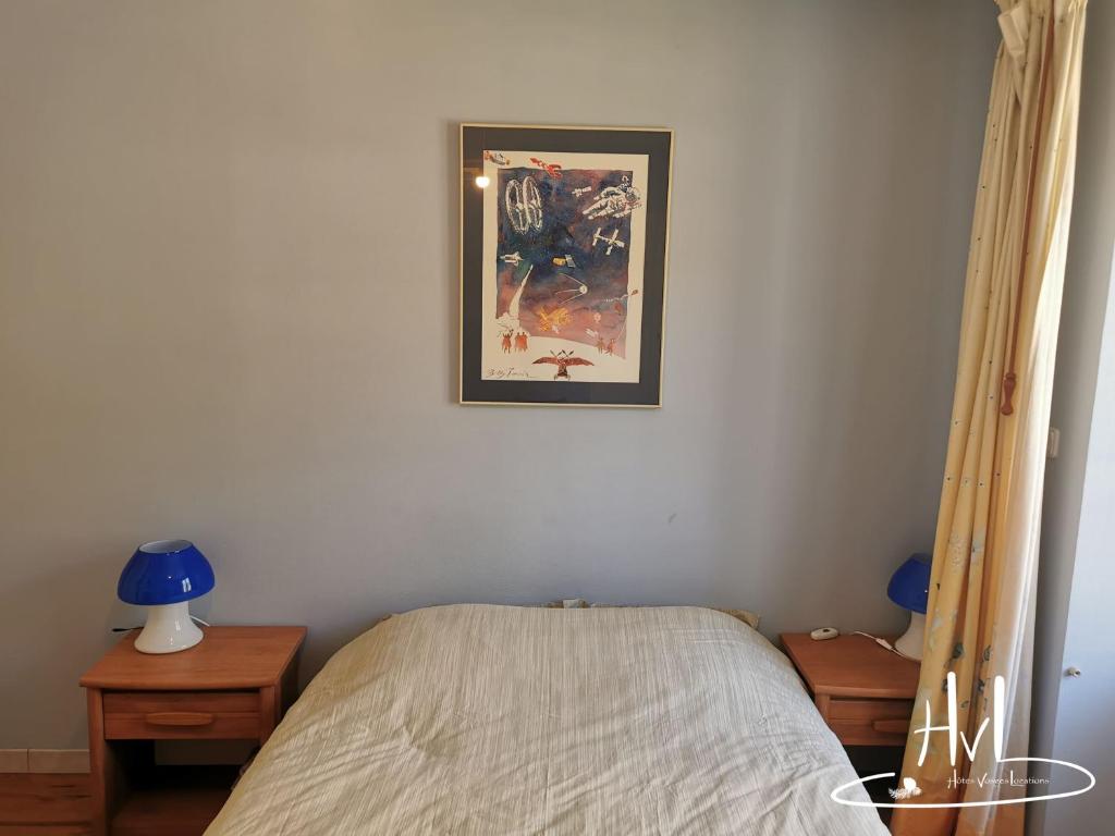 a bedroom with a bed and a picture on the wall at L appartement du chalet rose in Plombières-les-Bains