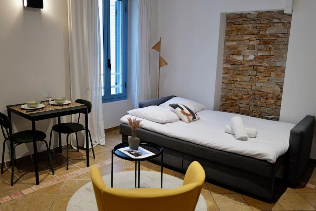 Habitación con cama, mesa y sillas. en Charmant studio à deux pas de Monaco, en Beausoleil