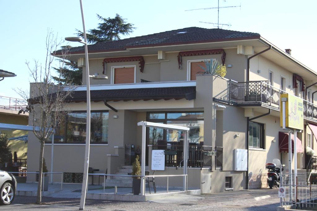 une maison avec une voiture garée devant elle dans l'établissement Hotel Margherita Meublè, à Sirmione