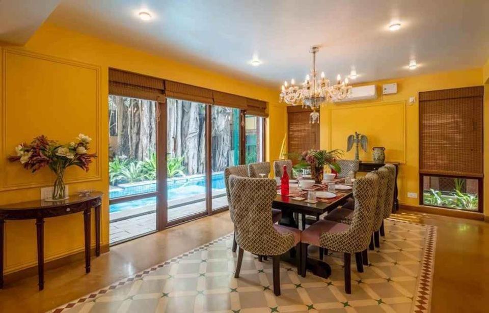 uma sala de jantar com paredes amarelas e uma mesa e cadeiras em Villa Beheira em Damanhûr