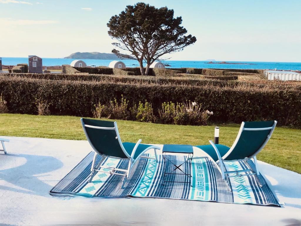 - deux chaises et une table avec vue sur l'océan dans l'établissement Nadia Residences de la mer 