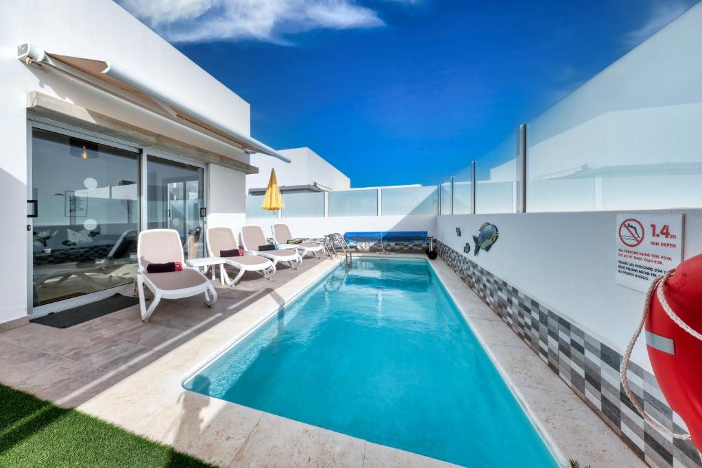 een zwembad op het dak van een huis bij Villa Cassia - Private Pool, Foosball, BBQ, Air-Con and SAT Tv By Lanzarote Vacation Homes in Playa Blanca